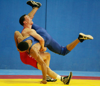 Puerto Rican Daniel Soto (red) wrestles Angelo Mota from the Dominican Republic during their combat in the men's 66kg wrestling competition at the 20th Central American and Caribbean Games in Cartagena, Colombia, July 24, 2006.