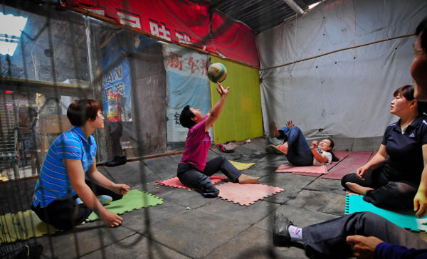 Zhang Wenli plays volleyball at the home of Li Yang, a disabled man in Yichang, Central China’s Hubei province, May 27, 2012. Disabled players team enjoys volleyball