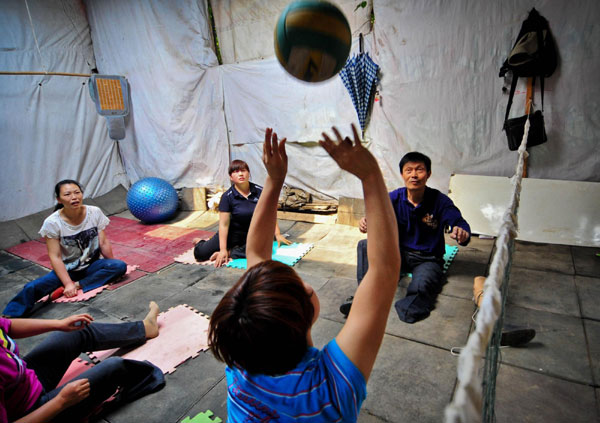 Li Yang plays volleyball with a team of disabled women in his house, May 27, 2012. Disabled players team enjoys volleyball