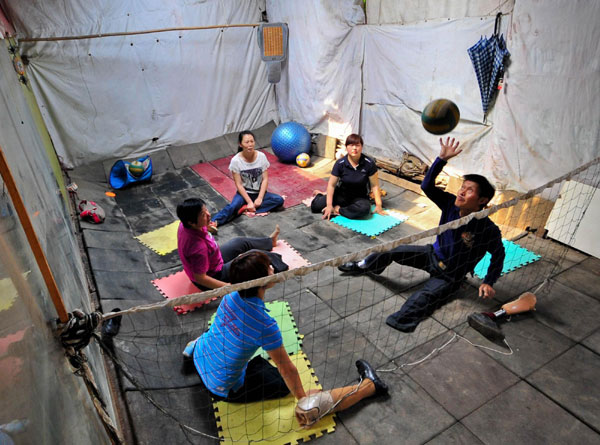 Li Yang plays volleyball with other disabled players at home, May 27, 2012. Disabled players team enjoys volleyball