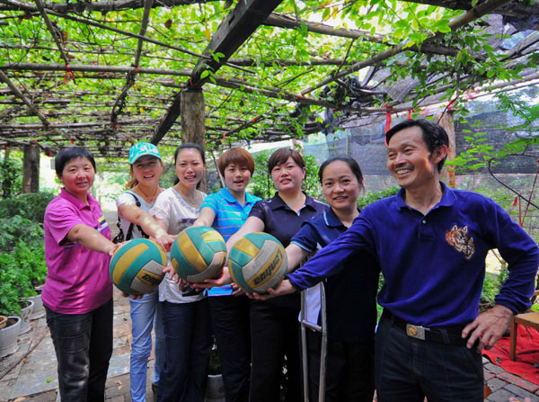 Li Yang poses for a photo with the disabled women’s volleyball team, May 27, 2012. Disabled players team enjoys volleyball