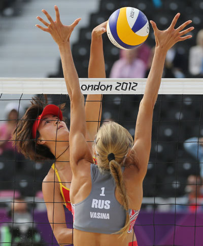 Zhang Xi (left) from China spikes a ball past Anastasia Vasina from Russia during their beach volleyball match on Saturday. Zhang and her partner Xue Chen lost 18-21, 21-14, 16-14. Petr David Josek / Associated Press Bikini beach party comes to Downing Street