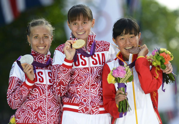 Russia's Elena Lashmanova (C) wears her gold medal as Russia's Olga Kaniskina (L) her silver and China's Choeyang Kyi her bronze during the women's 20km race walk victory ceremony at the London 2012 Olympic Games at The Mall August 11, 2012. China cheers for 1st Tibetan Olympic medalist
