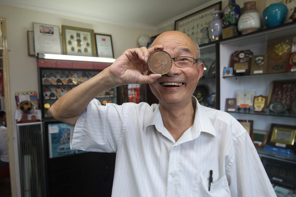 Chen Hongkang has a huge collection of Olympic and other Games medals and badges that he wants to share with other hobbyists. Zhang Xinyan / for China Daily Collecting memories and medals