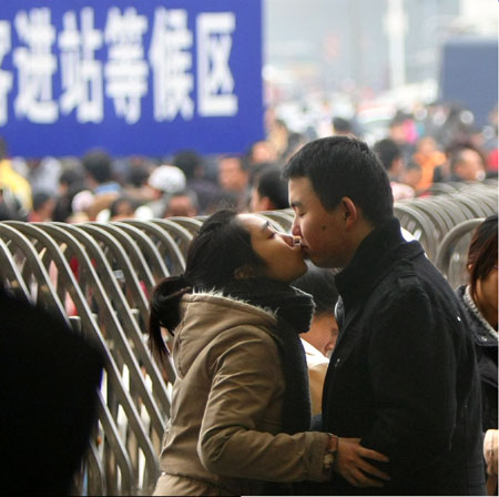 A man and a woman kiss goodbye at the Chengdu Railway Station, Sichuan province, on Monday. Provided to China Daily Micro blogs keep travelers informed