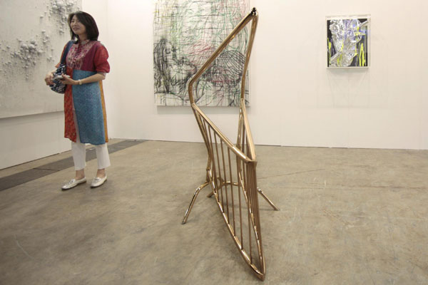A woman stands next to an installation titled 'Barricade' by artist Aaron Young of the US at the Hong Kong International Art Fair May 25, 2011. HK welcomes world's leading galleries