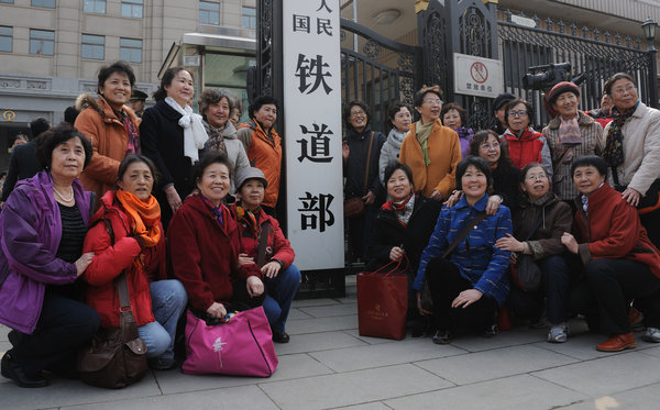 People take a group photo around the sign for the Ministry of Railways before it is changed, March 14, 2013. Keepsake photos of Railway Ministry