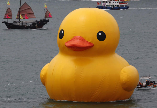 A traditional Chinese tourist junk sails past Rubber Duck by Dutch conceptual artist Florentijn Hofman at Hong Kong's Victoria Harbour May 2, 2013. Rubber duck sails Hong Kong
