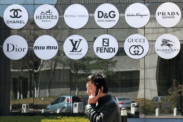 Luxury brand logos in a shop window in Beijing last month. Luxury sellers adapt to changing market