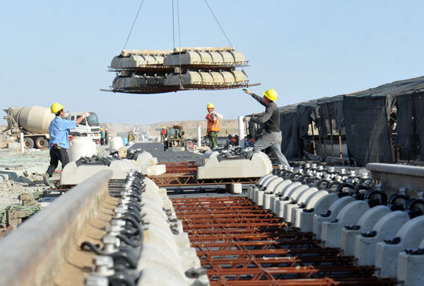 Workers unload parts for the ballastless track in Hami, part of the Lanzhou-Urumqi high-speed railway route. The project is scheduled for completion in 2014. Photos by Yao Tong / for China Daily Challenging times on 'high-speed Silk Road'