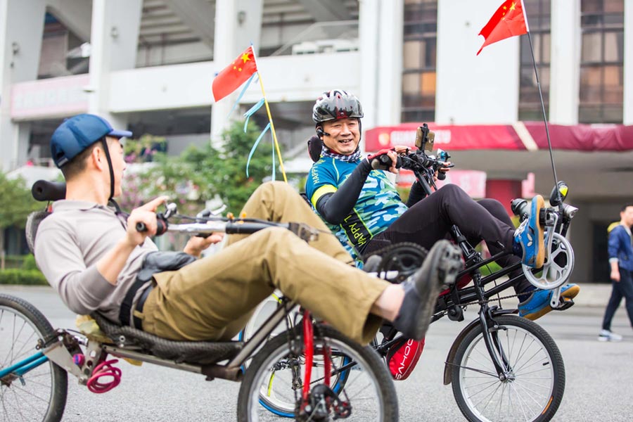 Cyclists sit back as they pedal through Guangzhou