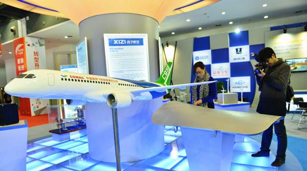 Visitors examine a model of China's first domestically designed commercial aircraft, COMAC's C919, at an exhibition in Beijing. Scientists used 3-D printing technologies to design components for the plane, such as the example pictured below right. Da Wei / for China Daily 3-D printing adds wings to aviation