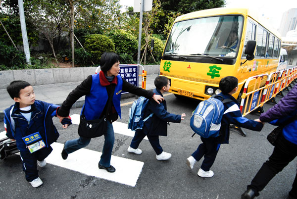 Pupils of a primary school prepare to take a school bus in Shenzhen, Guangdong province, on Jan 4. School bus makers split on safety draft