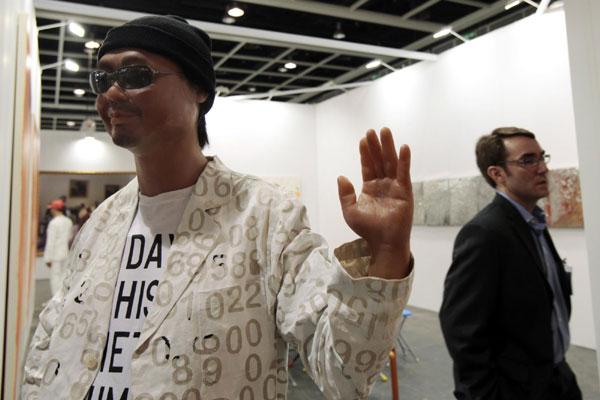 A man (R) walks past an art work titled 'Untitled 2011 (hello good-bye)' by Argentine artist Rirkrit Tiravanija at the Hong Kong International Art Fair May 25, 2011. HK welcomes world's leading galleries