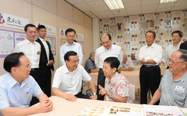 Chinese Vice-Premier Li Keqiang (L2) and Hong Kong's Chief Executive Donald Tsang (L) chat with elderly people as they visit community facilities for the elderly in Hong Kong August 16, 2011.[ Li visits Hong Kong elderly community
