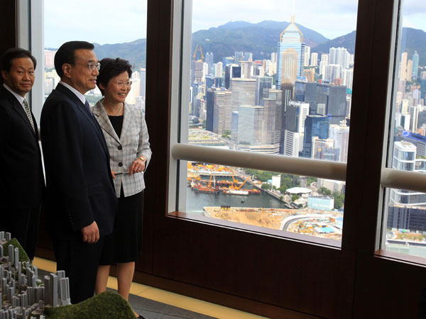 Chinese Vice-Premier Li Keqiang (L) chats with the Secretary for Development Carrie Lam in front of the background of Hong Kong's Victoria Harbour and business district, August 17, 2011. Vice-Premier Li visits HK Monetary Authority