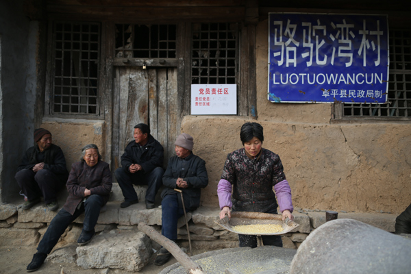 Villagers grind soybeans at a yard at Luotuowan village, Fuping County, Dec 31, 2013. Poor village gets $48 million after Xi's visit