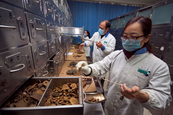 Workers prepare medicines at a traditional Chinese medicine hospital in Xiangyang, Hubei province. National program to keep TCM healthy