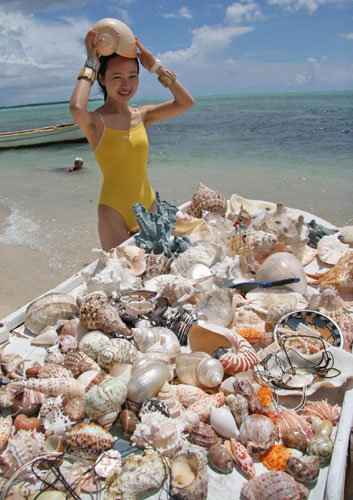 A vendor selling seashells attracts a Chinese tourist on the beach in Mauritius on Feb 10, 2005. The luxury of travel