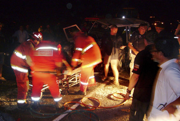 Firefighters attend to an injured person next to the wreckage of a support vehicle of team Race2Recovery after a car crash during the fifth stage of the Dakar Rally 2013 in Tacna, on Jan 9, 2013. Two dead, seven injured in Dakar Rally accident