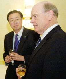 China's central bank Governor Zhou Xiaochuan (L) and U.S. Treasury Secretary John Snow talk over drinks before a dinner in Washington April 21, 2006. The two are in Washington for a round of G7 meetings.