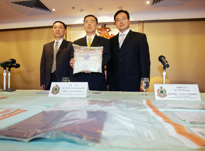 Customs officers Song Min (L), deputy director general of anti-smuggling bureau of the Shenzhen Customs, Ben Leung (C), Hong Kong's head of customs drug investigation bureau and Sin Wai-sun, divisional commander of Hong Kong's drug investigation, display seized cocaine and related props during a news conference in Hong Kong May 9, 2006. Hong Kong, China and U.S. drug enforcement bureaus have smashed a Colombia-based cocaine trafficking syndicate. A total of 142-kilograms of cocaine, with an estimated market value of HK105 million ($134,600) and a nine people were netted in mainland China and Hong Kong. The nine made up of three Colombians, a Venezuelan, three Chinese and two Hong Kong residents.