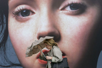 A woman braves gusty wind outside a shopping mall at a tourist district in Hong Kong May 17, 2006. Hong Kong, Taiwan and provinces on China's southern coast were on alert on Wednesday as Typhoon Chanchu churned northward after tearing across the Philippines killing 37 people. The Hong Kong Observatory issued a strong wind signal number three, which means that winds with mean speeds of 41-62 kmh (25.5-38.5 mph) were expected in the former British colony.