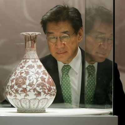 Theow Tow, Deputy Chairman of Christie's Asia and the Americas International Director of Chinese works of Arts, looks at an early Ming underglaze copper-red vase after it was sold for a world record of US$10,122,558 for any Ming porcelain during an auction in Hong Kong May 30, 2006.