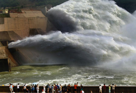 Tourists watch water flush out of the sluice of the Xiaolangdi Dam on the Yellow River in Central China's Henan Province June 18, 2006. The view attracts more than 10,000 visitors from across the country. [Xinhua]