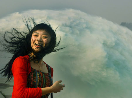 A tourist watches water flush out of the sluice of the Xiaolangdi Dam on the Yellow River in Central China's Henan Province June 18, 2006. The view attracts more than 10,000 visitors from across the country. [Xinhua]