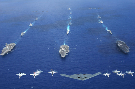An Air Force B-2 bomber along with other aircrafts from the Air Force, Navy and Marine Corps fly over the Kitty Hawk, Ronald Reagan and Abraham Lincoln Carrier Strike groups