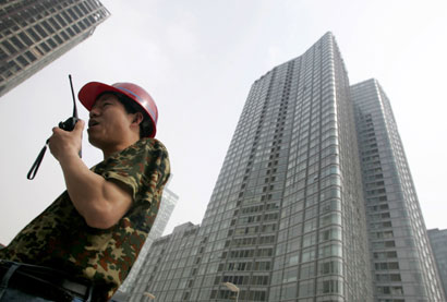 A worker uses a walkie-talkie at a construction site in China's capital Beijing May 18, 2006.