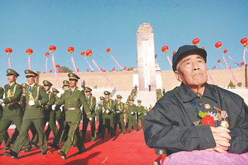 Veteran Red Army soldier Li Zhanrong, 86, sits in front of the Long March Monument at Jiangtaibao of Xiji County in Northwest China's Ningxia Hui Autonomous Region yesterday. The Long March ended at Jiangtaibao on October 22, 1936, after which the Red Army headed to Yan'an where the new CPC headquarters was established. (Xinhua)