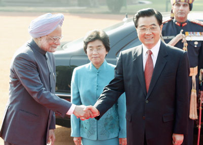 China's President Hu Jintao (R) shakes hands with Indian Prime Minister Manmohan Singh as Hu's wife Liu Yongqing (C) watches during a ceremonial reception at the presidential palace in New Delhi November 21, 2006.