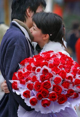 A Chinese woman hugs her boyfriend after receiving a bunch of roses during Valentine's Day in Nanjing, capital of east China's Jiangsu province February 14, 2006. 
