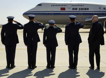 U.S. Treasury Secretary Henry Paulson (R) waits with a U.S. Air Force welcoming committee for China's Vice Premier Wu Yi upon her aircraft's arrival at Andrews Air Force Base near Washington, May 21, 2007.