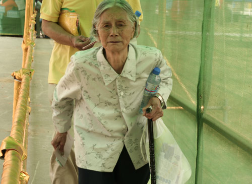 An aged woman waits to cast a vote on the demolishment and reconstruction of old buildings in Juixiaqiao Sub-district in Beijing, June 9, 2007. Local government and the real estate developer jointly organize the vote on Saturday to see if majority residents of over 5000 families accept the new compensation policy after failed attempts to reach an agreement through other ways. Both notary officials and supervisors are invited to monitor the vote that runs from 9 a.m. to 9 p.m. at six ballot booths. [Sun Yuqing/www.szjzcy.com]