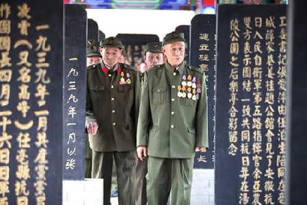 Chinese veterans stand amid the tombstones of soldiers who were killed during the war against the Japanese invaders in 1930s and 1940s, at a martyr cemetery in Bozhou, in East China's Anhui province, on Monday Remembering a wound