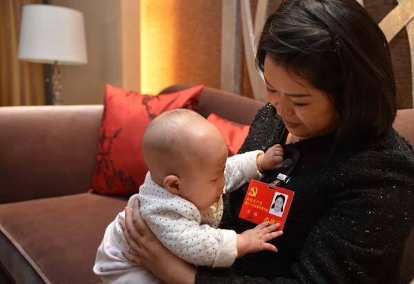Luo Wei, a deputy to the 18th National Congress of the Communist Party of China, takes care of her five-month-old daughter at a hotel after finishing a group discussion in Beijing on Nov 10, 2012. Luo, who took her baby to Beijing as she is still breastfeeding, is the youngest deputy of Southwest China's Sichuan province delegation and donated 55 percent of her liver to save the life of an unrelated person in 2005. From congress delegate to caring mom