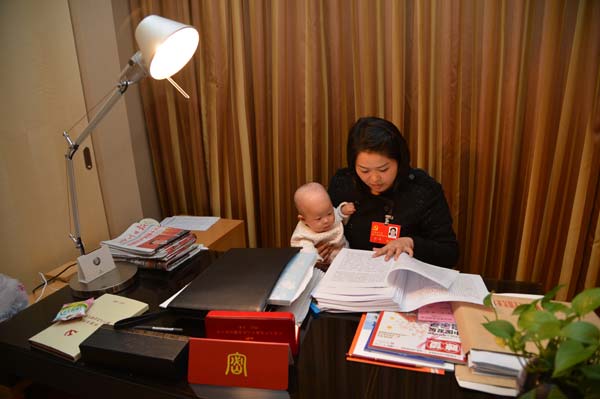 Luo Wei, a deputy to the 18th National Congress of the Communist Party of China, takes care of her five-month-old daughter at a hotel after finishing a group discussion in Beijing on Nov 10, 2012. Luo, who took her baby to Beijing as she is still breastfeeding, is the youngest deputy of Southwest China's Sichuan province delegation and donated 55 percent of her liver to save the life of an unrelated person in 2005. From congress delegate to caring mom