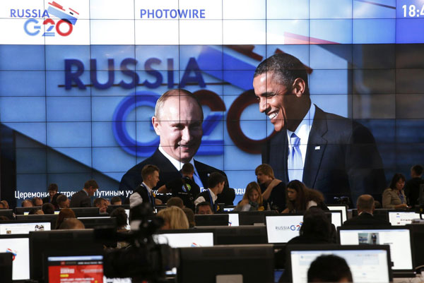 Russian President Vladimir Putin (L) and U.S. President Barack Obama are pictured on a video screen installed in the press centre of the G20 Summit in Strelna near St. Petersburg, September 5, 2013. Obama, Putin meet for G20 at St petersburg