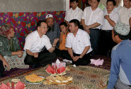 Chinese Premier Wen Jiabao (2nd L) talks with local people at a villager's home during his inspection tour to the northwestern Xinjiang Uygur Autonomous Region from last Thursday to Sunday. Wen Jiabao visited villages, schools, enterprises, hospitals and the Xinjiang production and construction corps of the army in a number of prefectures and cities to show his extensive care for local people's livelihood, education, medical service and the development of energy sources，Xinhua reported.[Xinhua]