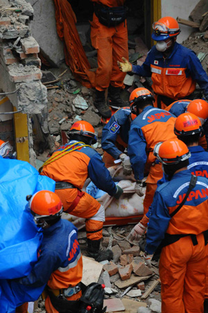 Members of the Japanese rescue team package the body of a victim at Qiaozhuang Town of Qingchuan County in the quake-stricken southwest China's Sichuan Province, May 17, 2008. Japanese earthquake rescuers found two corpses in a collapsed six-floor building in Qiaozhuang at 7:25 am after 16 hours rescue operation. (Xinhua/Li Tao)