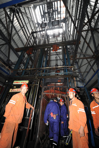Rescue workers take a lift on Thursday down a mineshaft to continue their efforts to reach 28 miners who were trapped after a fire broke out underground on Wednesday in Zaozhuang, Shandong province. Fire traps 28 miners underground