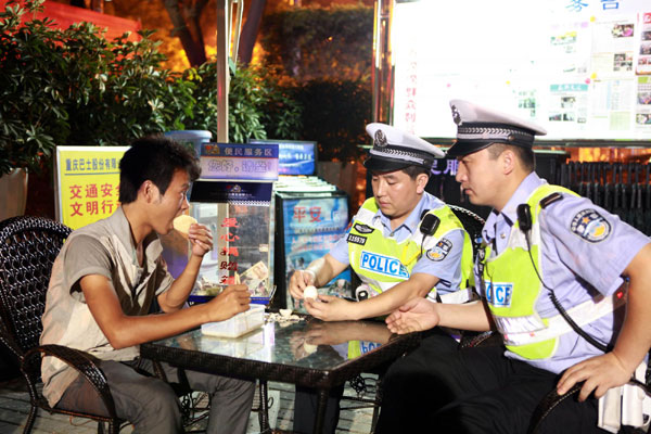 Jing Weiquan enjoys a free breakfast after seeking help from police officers in Southwest Chongqing municipality early on the morning of July 14, 2011.[ Gutsy 7 day, 360 km hike to find a job