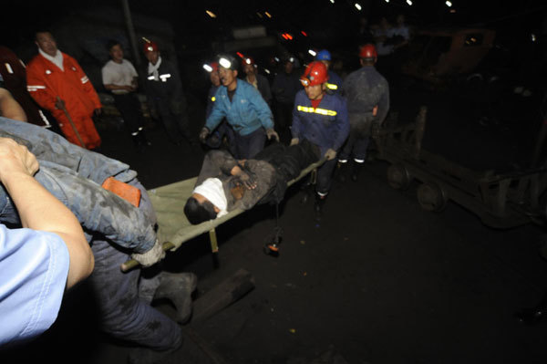 A miner rescued from a flooded pit of the Hengtai Coal Mining Co is carried away on a stretcher in Boli county, Northeast China’s Heilongjiiang province, August 27, 2011. 3 of 26 trapped rescued after NE China mine flood