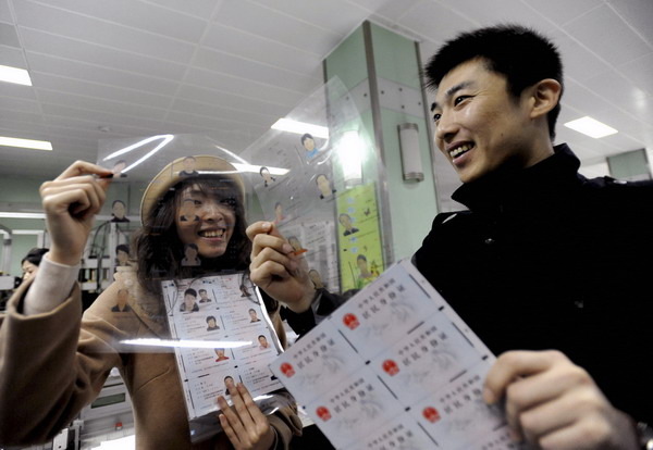 Residents in Shenyang, capital of Northeast China's Liaoning province, look at templates of the second generation ID card during their visit to the provincial public security department on March 23. ID cards may carry fingerprint data