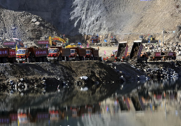 Trucks unload soil and gravel to block the river stream at Pondo Water Control Project in Tibet, Oct 26, 2011. Tibet's largest water project completes damming