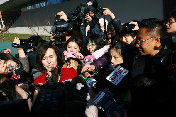 Kim Lee (center), the wife of Li Yang (right), founder of a famous English-language education institution in China, talks to reporters after the couple's divorce hearing at a Beijing court on Thursday. Provided to China Daily Crazy English couple go to court