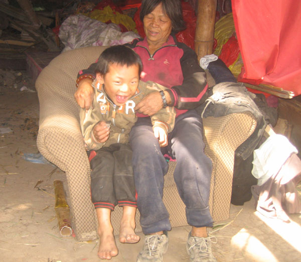 Huang Jinlian, 75, sits with Wu Tiansheng, 7, at her home in Qinzhou, the Guangxi Zhuang autonomous region, in December. Tiansheng was an infant when Huang found him abandoned in a cardboard box, and she took him back home to live with her. Huang Zhaohua / China Daily Hardscrabble life for orphan and 'mom'